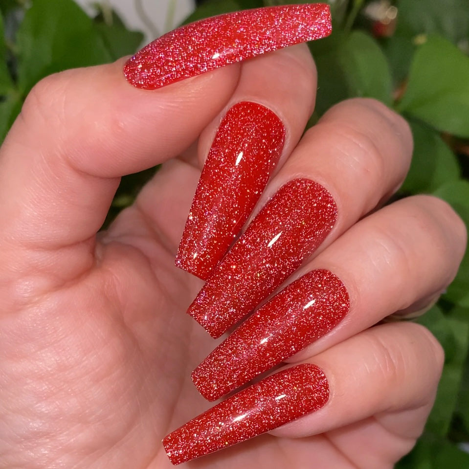 Red reflective glitter fake nails.